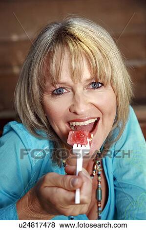 Female mature adult eating watermelon View Large Photo Image Stock Photo - Female mature adult eating watermelon. Fotosearch