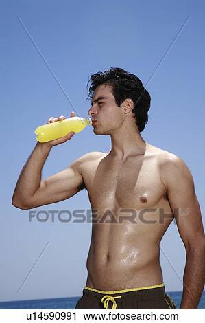 Stock Image - Male young adult drinking juice. Fotosearch