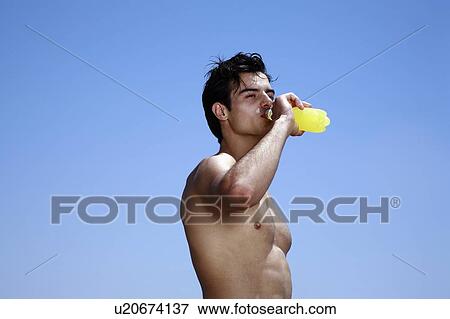 Male young adult drinking juice View Large Photo Image Stock Photo - Male young adult drinking juice. Fotosearch
