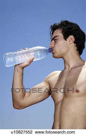 Male young adult drinking water from a bottle View Large Photo Image Stock Image - Male young adult drinking water from a bottle. Fotosearch
