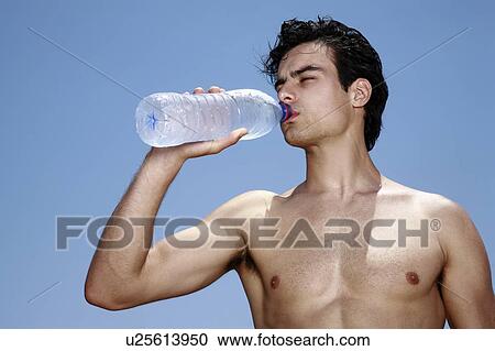 Male young adult drinking water from a bottle View Large Photo Image Stock Image - Male young adult drinking water from a bottle. Fotosearch