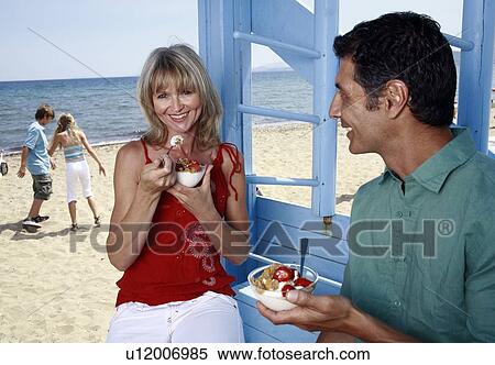 Mature adult couple eating breakfast at beach View Large Photo Image Stock Photography - Mature adult couple eating breakfast at beach. Fotosearch