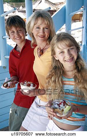 Stock Photo - Mother with children eating at beach. Fotosearch