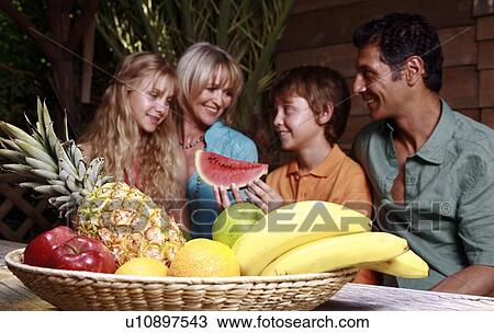 Stock Image - Parents with children and fruit. Fotosearch