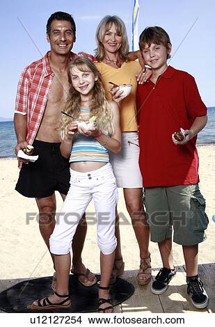 Picture - Parents with children eating at beach. Fotosearch