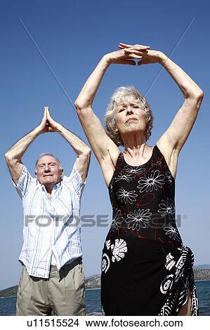 Senior couple stretching on beach View Large Photo Image Picture - Senior couple stretching on beach. Fotosearch