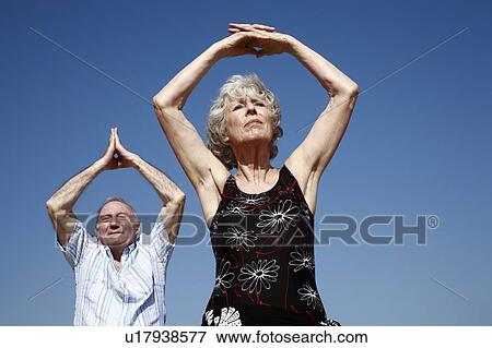Stock Photo - Senior couple stretching. Fotosearch
