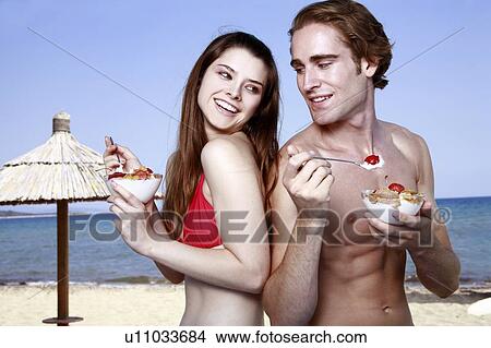 Young adult couple eating breakfast on beach View Large Photo Image Picture - Young adult couple eating breakfast on beach. Fotosearch