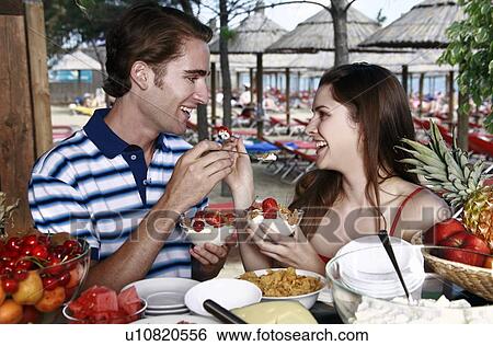 Young adult couple eating breakfast View Large Photo Image Stock Photograph - Young adult couple eating breakfast. Fotosearch