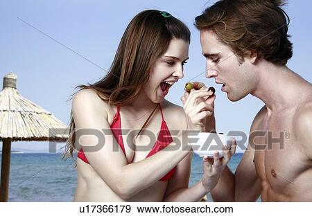 Young adult couple feeding each other View Large Photo Image Stock Photo - Young adult couple feeding each other. Fotosearch