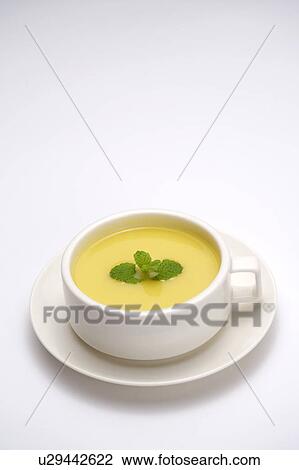 Stock Image - Bowl of soup on plate, elevated view. Fotosearch