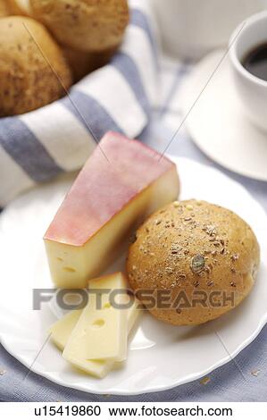 Stock Image - Bun with cheese and cake on plate. Fotosearch