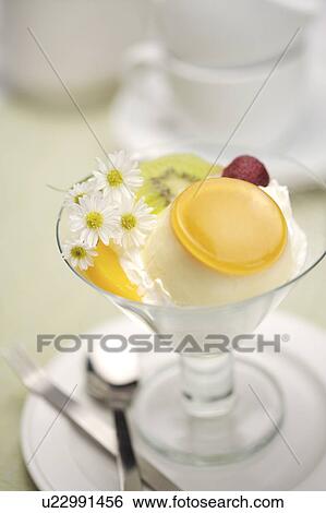 Stock Photograph - Ice cream in glass with fruit topping. Fotosearch