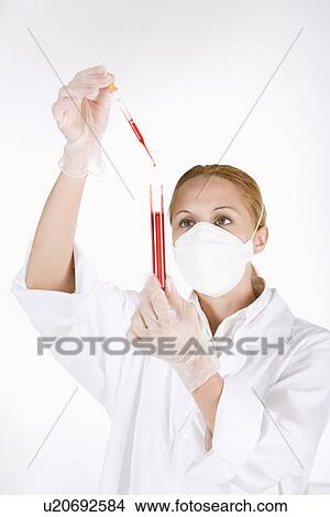 Female scientist dropping liquids into test tube with pipette View Large Photo Image Picture - Female scientist dropping liquids into test tube with pipette . Fotosearch