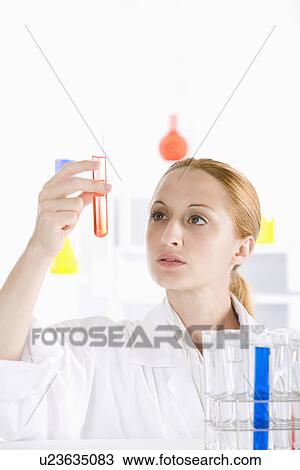 One woman holding up test tube with liquid View Large Photo Image Stock Image - One woman holding up test tube with liquid. Fotosearch