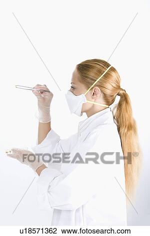 One woman in lab coat examining seed, side view View Large Photo Image Stock Image - One woman in lab coat examining seed, side view. Fotosearch