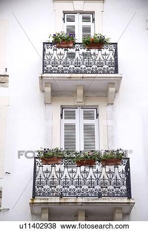 Stock Photo - Balconies with flowers by windows. Fotosearch
