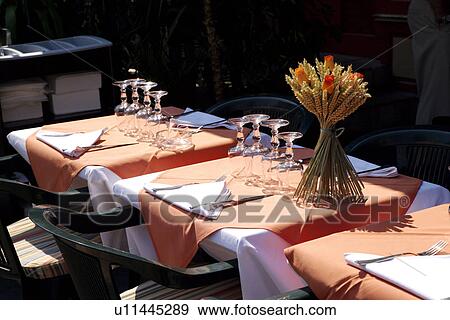 Stock Photo - Tables with bunch of flowers in glass vase. Fotosearch