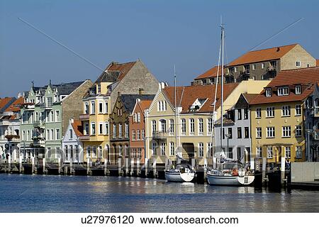 Stock Image - Houses by river with boats. Fotosearch