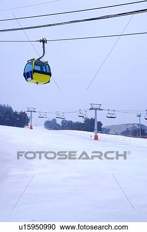 Stock Image - Cable car and ski lift on ski resort, focus on cable car. Fotosearch