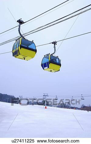 Stock Photography - Two cable cars hanging in the mid-air. Fotosearch