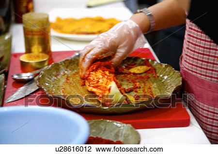 Stock Image - Woman making kimchi. Fotosearch