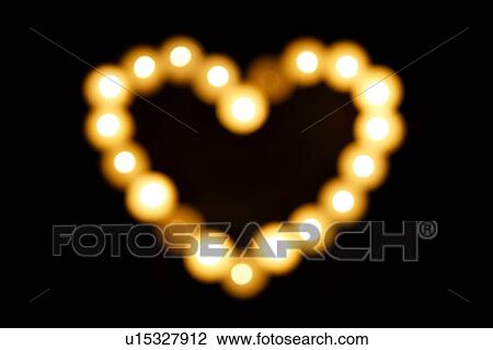 Stock Image - Lit candles in heart shape. Fotosearch