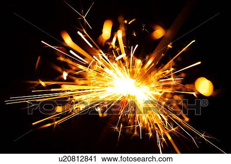 Stock Image - Sparkler against black background. Fotosearch