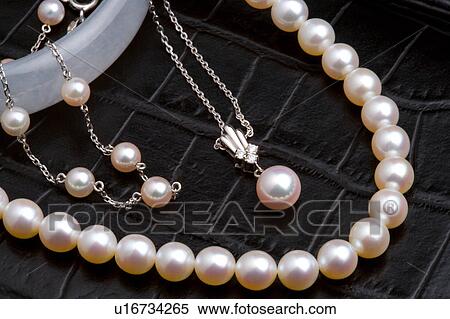 Stock Photography - Pearl necklaces on leather surface. Fotosearch