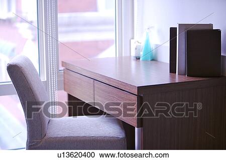 Stock Image - Desk and chair by window. Fotosearch