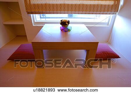Stock Image - Sitting room with cushions by window. Fotosearch