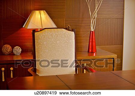 Stock Photo - Table and chair with lamp in the background. Fotosearch