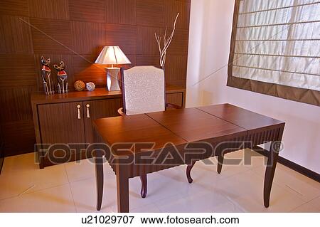 Stock Photo - Table and chair with lamp in the background. Fotosearch
