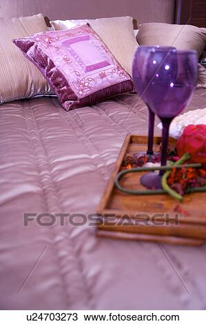 Stock Image - A tray of flowers and goblets on the bed. Fotosearch