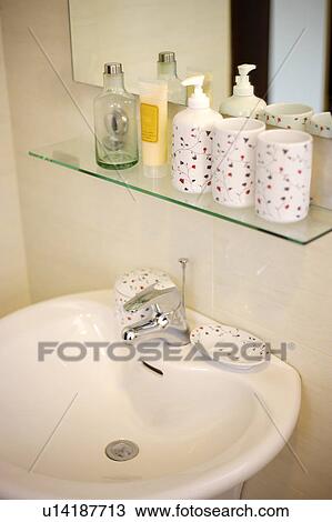 Bathroom sink along with a shelf of toiletries View Large Photo Image Stock Image - Bathroom sink along with a shelf of toiletries. Fotosearch