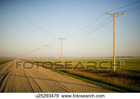 Stock Photo - Gravelled road at sunset in rural Saskatchewan, Canada. Fotosearch