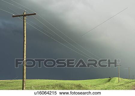 Stock Photography - Stormy sky and sunlight on hydro-electric power lines, rural Manitoba, Canada. Fotosearch