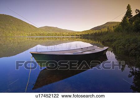 Stock Image - View of boat at Lebreux lake at sunset, Quebec. Fotosearch
