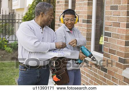 Stock Image - African American couple doing home improvement, Vancouver, BC. Fotosearch