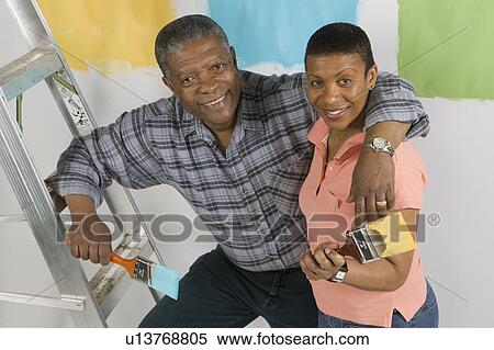 Stock Photography - African American Couple Doing Home Improvement Painting, Canada, British Columbia. Fotosearch