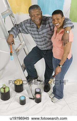 Stock Photography - African American Couple Doing Home Improvement Painting, Canada, British Columbia. Fotosearch