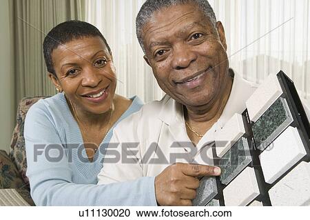 Stock Image - African American couple going over granite samples, Vancouver, BC. Fotosearch