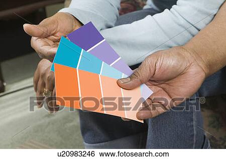 Stock Photograph - African American couple going over paint colour swatches, Vancouver, BC. Fotosearch