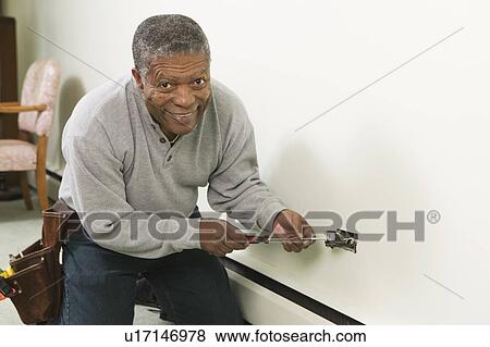 African American man working on a household receptacle, B. C. View Large Photo Image Stock Photo - African American man working on a household receptacle, B. C.. Fotosearch
