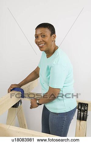 Stock Image - African American Woman Doing Home Improvement, Canada, British Columbia. Fotosearch
