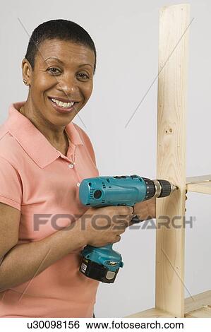 African American Woman Doing Home Improvement, Assembling a Shelving Unit, B. C. View Large Photo Image Stock Photograph - African American Woman Doing Home Improvement, Assembling a Shelving Unit, B. C.. Fotosearch