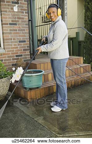 Picture - African American woman using a power washer, Vancouver, BC. Fotosearch
