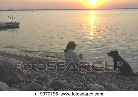 Woman with dog at beach Clear Lake; Canada, Manitoba, Riding Mountain National Park View Large Photo Image Stock Photograph - Woman with dog at beach Clear Lake; Canada, Manitoba, Riding Mountain National Park. Fotosearch