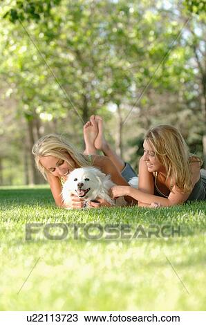 Stock Image - 2 young blonde females in park, Regina, Saskatchewan. Fotosearch