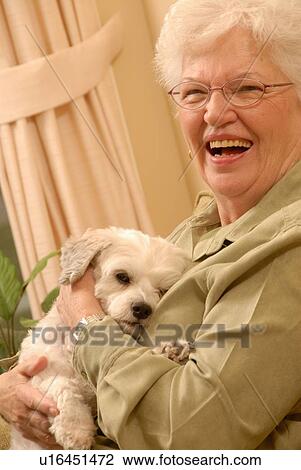 Stock Image - Senior Woman with white dog, Regina, Saskatchewan. Fotosearch